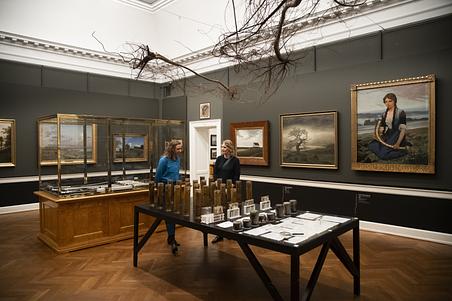 Gæster betragter Rune Bosses værker 'Jordoptagelser' og 'Infinity root' i museets havesal. Foto: Jacob Ljørring.
